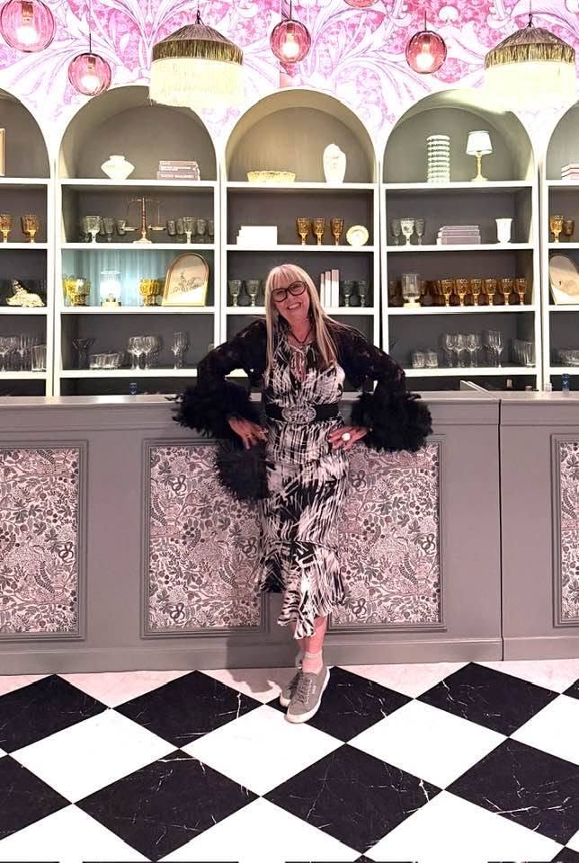 Bonnie Roseman in a black-and-white printed dress with feathered sleeves at a bar