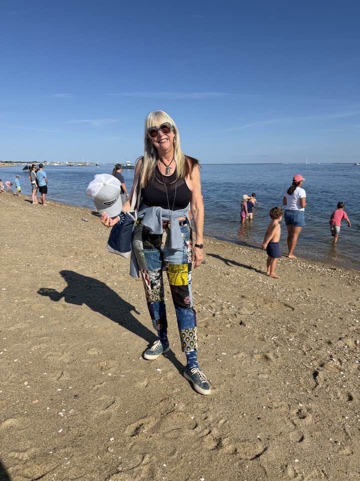 Bonnie Roseman on a Nantucket beach in a patchwork denim outfit and sunglasses
